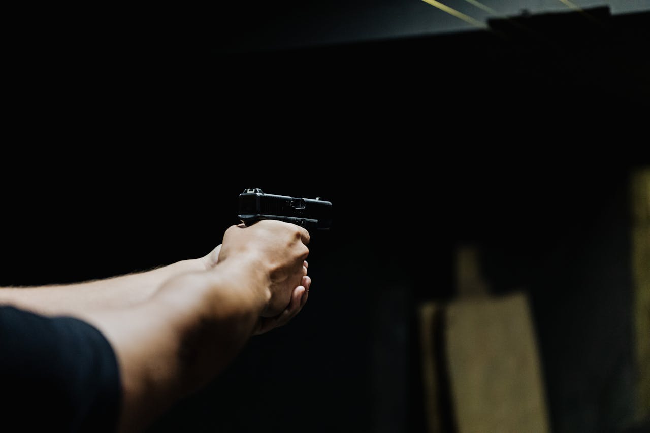 Mastering the First Impression: Your intriguing post title goes here Arm aiming a handgun in a dark environment, showcasing focus and control.